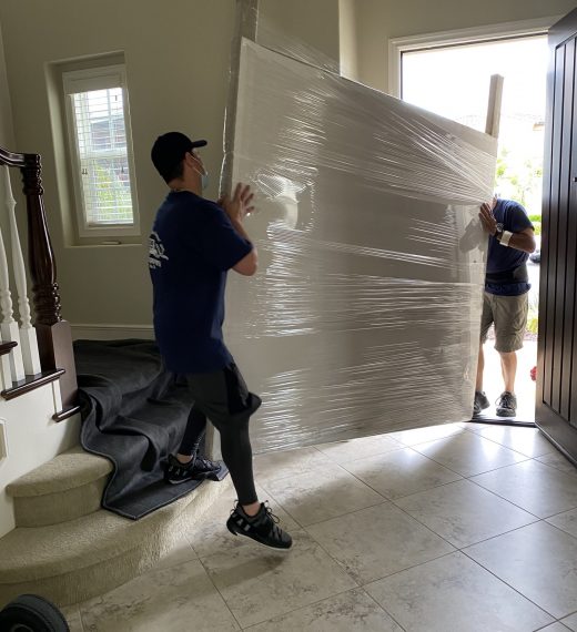 strong-professional-movers-move-a-large-headboar-2024-09-18-18-28-29-utc